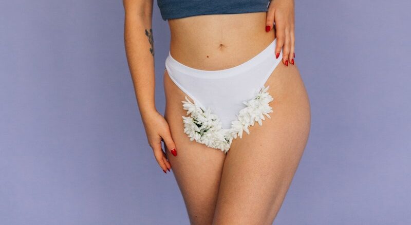 A Sexy Woman in White Panty with Flowers Between Her Legs