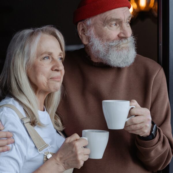 Man and Woman Holding White Ceramic Mugs