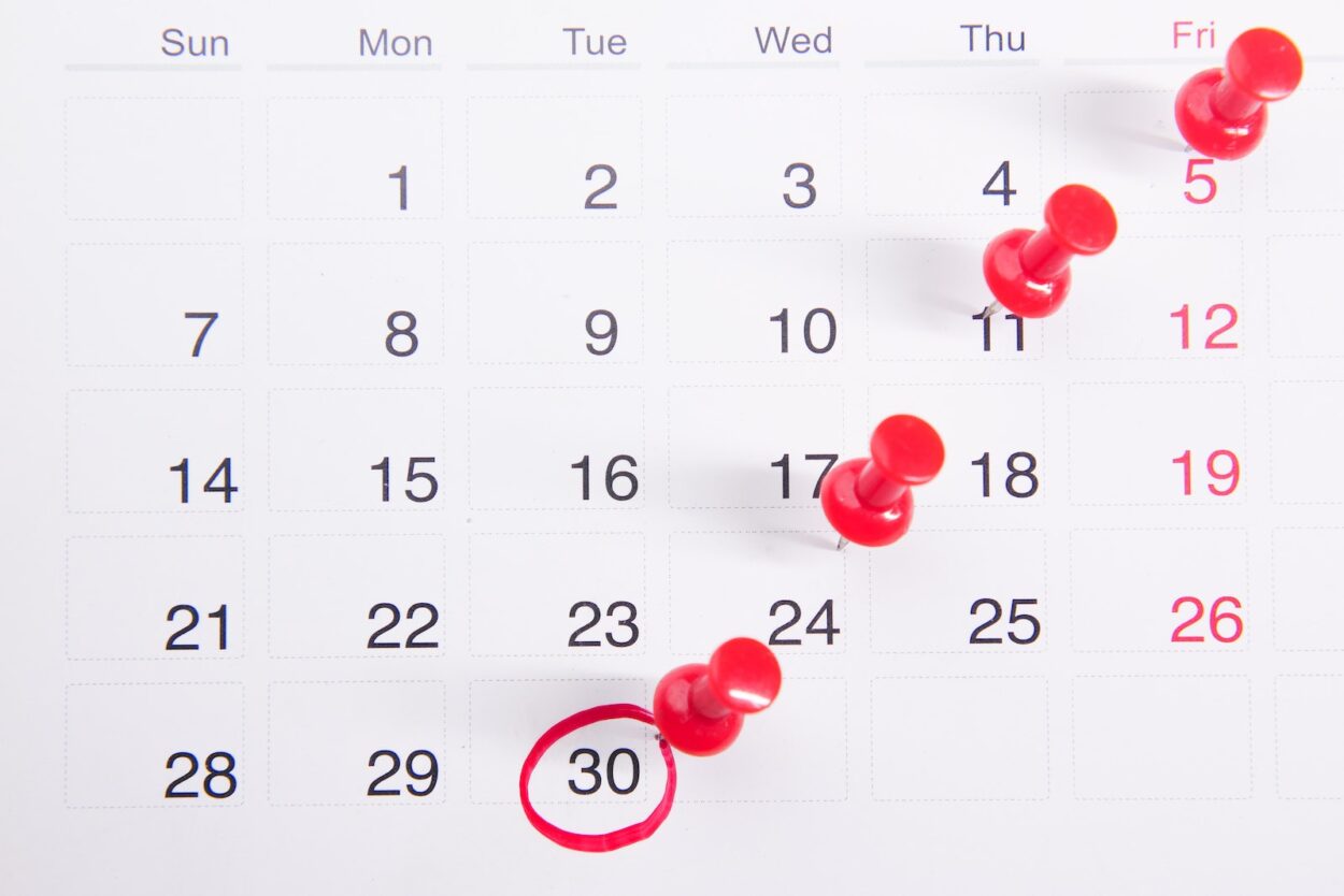 Close-up Photo of Red Pins on a Calendar