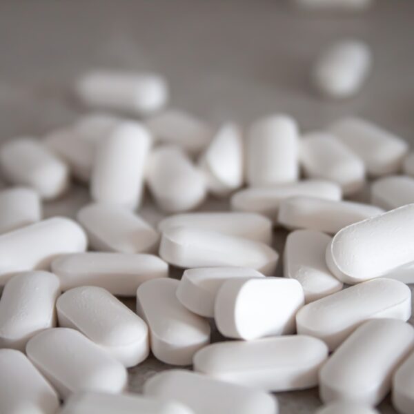 white medication pills on brown surface